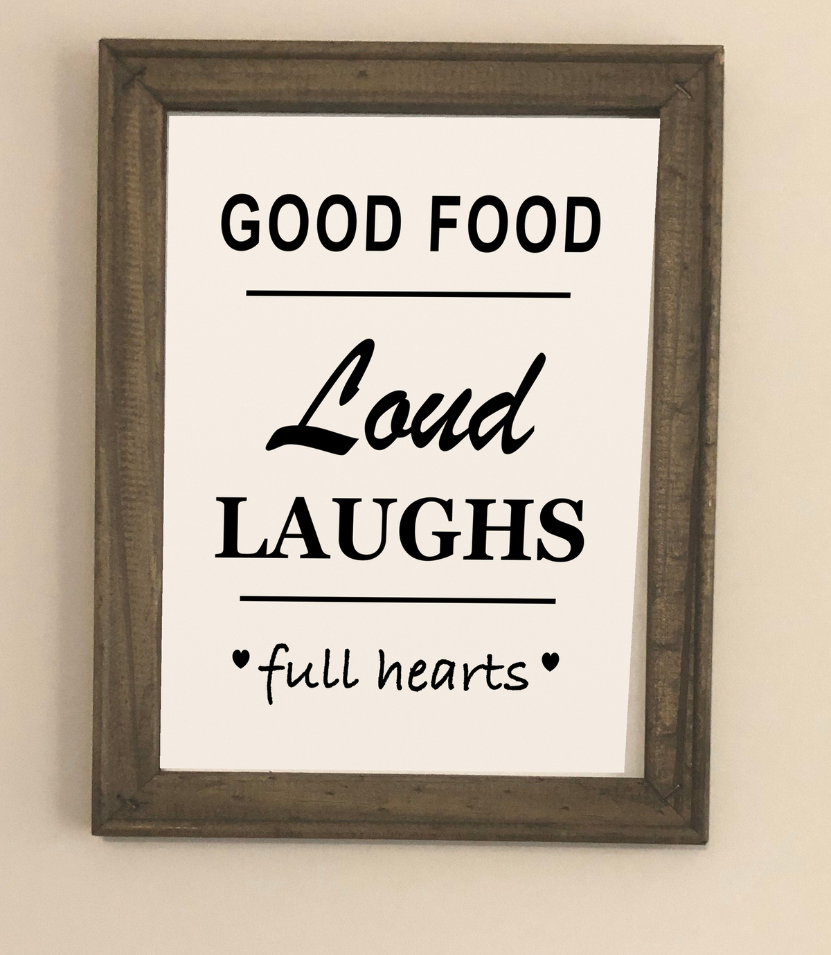 Good Food Loud Laughs Full Hearts framed canvas sign displayed on a neutral wall
