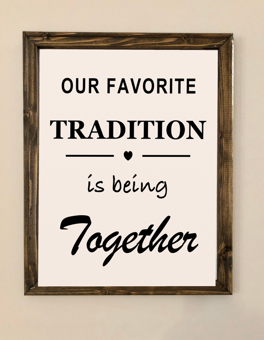 Our Favorite Tradition Is Being Together framed canvas sign displayed on a neutral wall